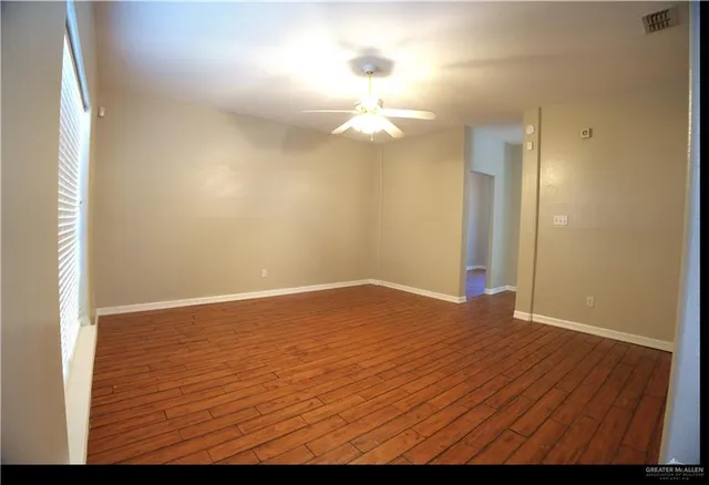 a view of empty room with wooden floor