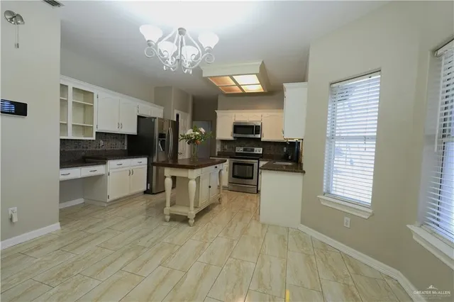 a kitchen with cabinets a sink and stainless steel appliances