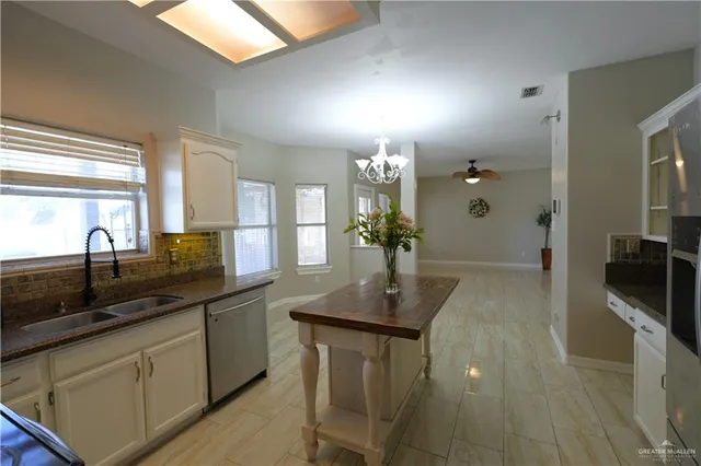 a kitchen with stainless steel appliances granite countertop a sink a stove and a wooden floors