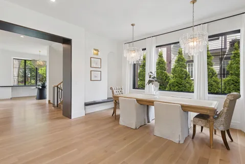 a view of a large dining room with wooden floor and windows