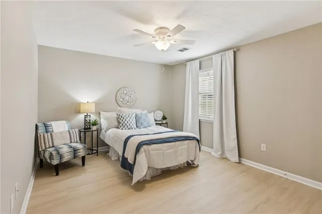 a spacious bedroom with a bed and a chandelier