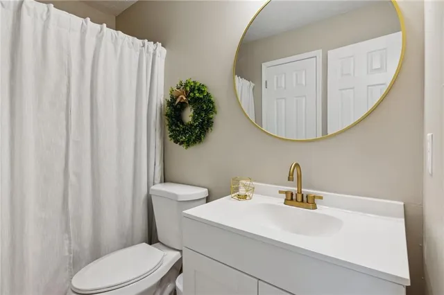 a bathroom with a sink a toilet and a mirror