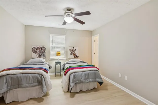 a bedroom with two beds and painting on the wall