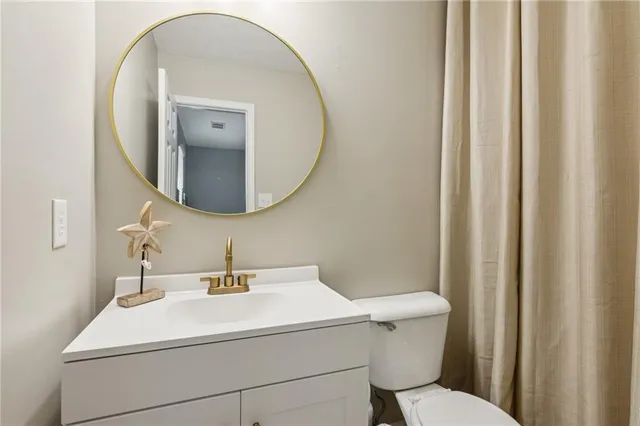 a bathroom with a sink mirror and toilet