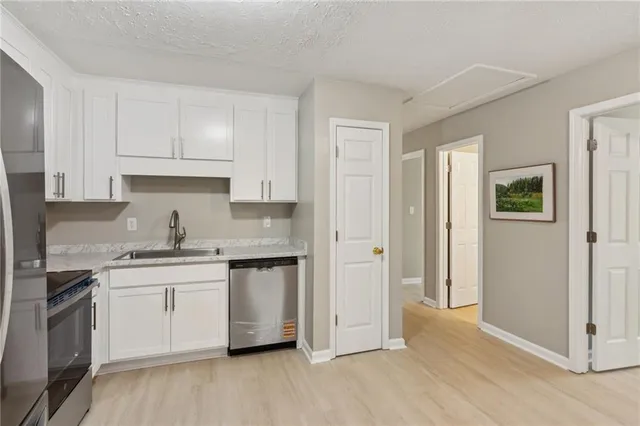 a kitchen with stainless steel appliances granite countertop a sink and a stove top oven
