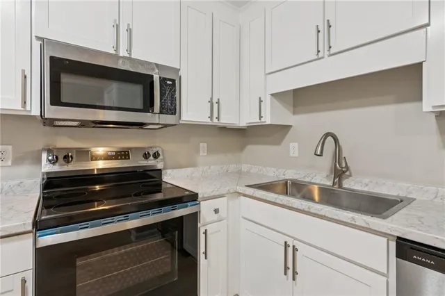 a kitchen with stainless steel appliances a stove a microwave and sink