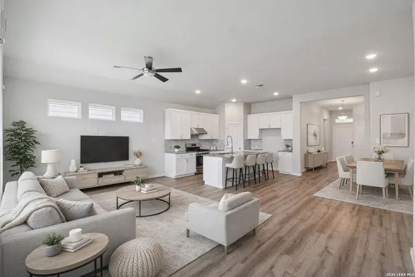 a living room with furniture kitchen view and a large window