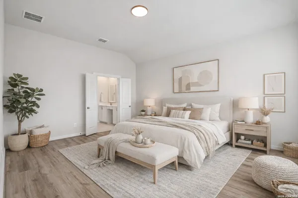 a spacious bedroom with a bed and a potted plant