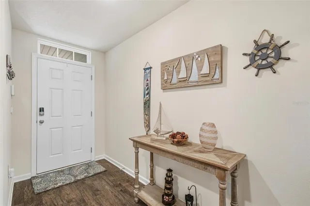 a kitchen with stainless steel appliances a stove a sink a microwave a refrigerator white cabinets and wooden floor