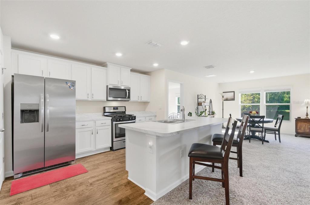 2 Pinnacle Place Bunnell, FL 32110 - Photo 10 of 83 a kitchen with stainless steel appliances kitchen island granite countertop a table and chairs