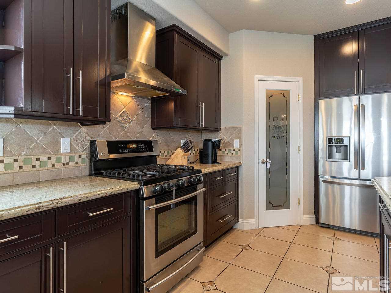 13520 Rim Rock Drive Reno, NV 89521 - Photo 18 of 25 a kitchen with stainless steel appliances granite countertop a stove a refrigerator and a sink