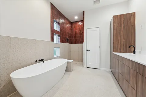 a spacious bathroom with a double vanity sink a mirror a vanity and a bathtub