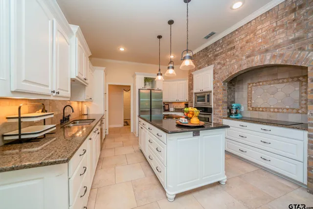 a kitchen with stainless steel appliances granite countertop a sink a stove and refrigerator