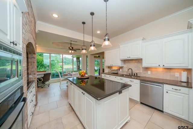a kitchen with stainless steel appliances granite countertop a sink and a refrigerator