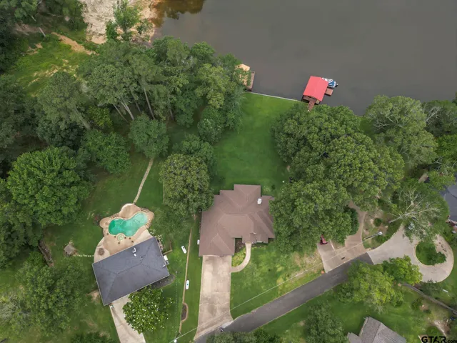 an aerial view of house with yard and lake view