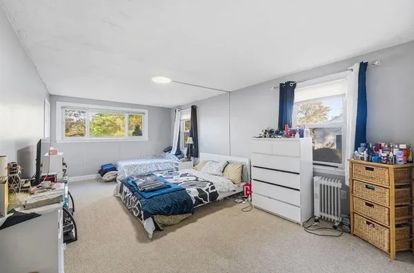 a bedroom with a bed and furniture with a flat tv screen