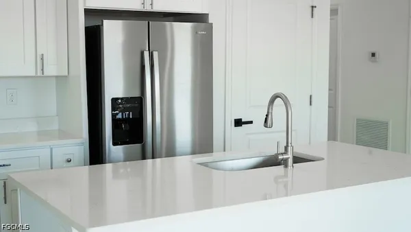 a kitchen with a refrigerator and a sink