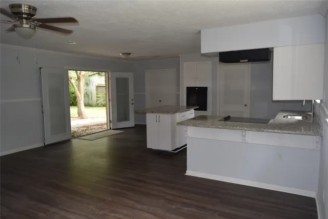 a room with a chandelier and wooden floor