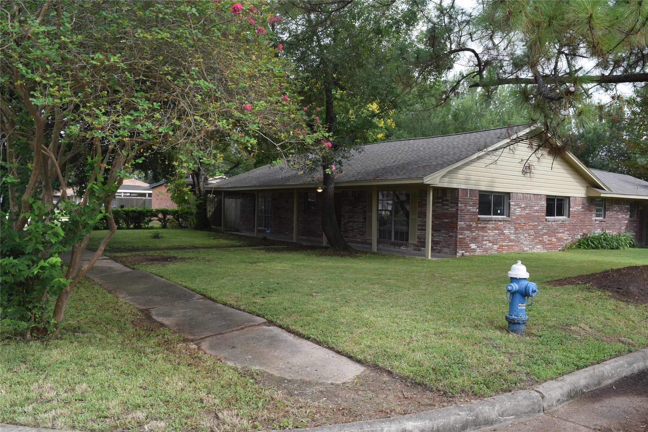 9902 Tolman Street Houston, TX 77034 - Photo 23 of 26 a front view of a house with a garden and trees
