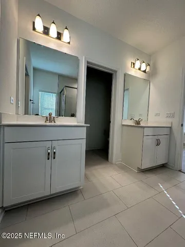 a bathroom with a sink vanity and mirror