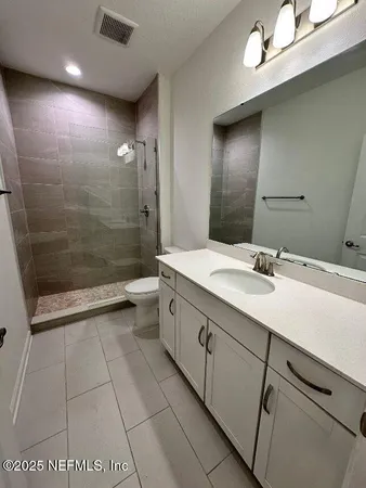 a spacious bathroom with a granite countertop sink a toilet and shower