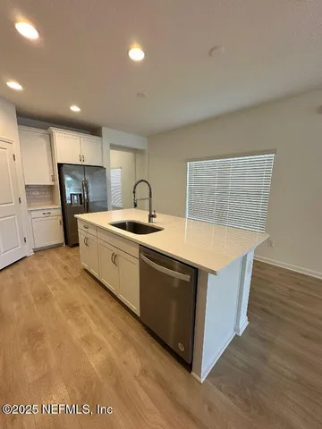 a kitchen with stainless steel appliances granite countertop a sink a stove and a refrigerator