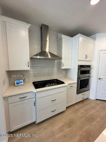 a kitchen with granite countertop white cabinets and white appliances