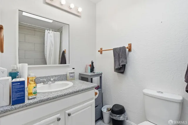 a bathroom with a granite countertop sink and a mirror