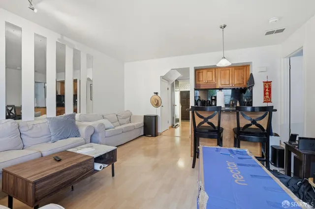 a living room with furniture a wooden floor and a chandelier