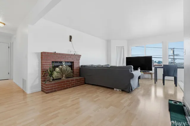 a living room with furniture a flat screen tv and a fireplace