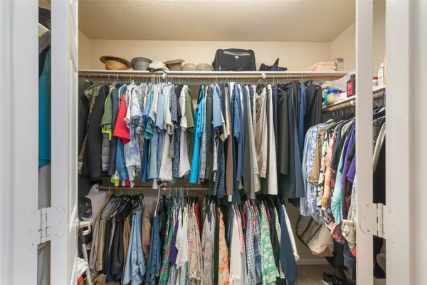 a view of walk in closet with clothes