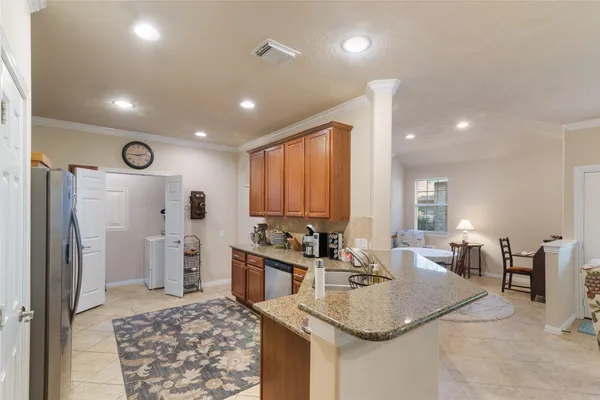 a kitchen with stainless steel appliances granite countertop a sink refrigerator and cabinets