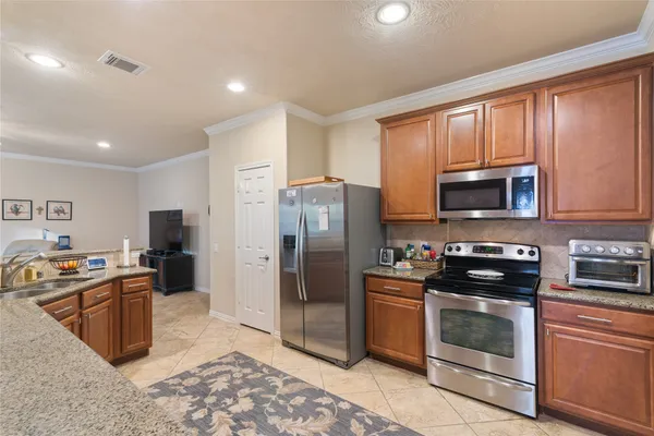 a kitchen with stainless steel appliances granite countertop a stove a refrigerator and a sink