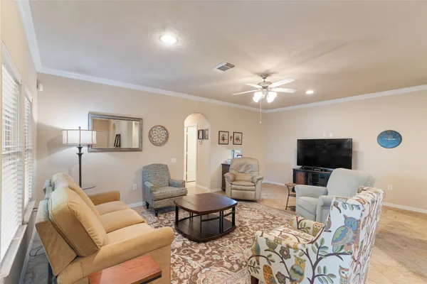 a living room with furniture a flat screen tv and a chandelier
