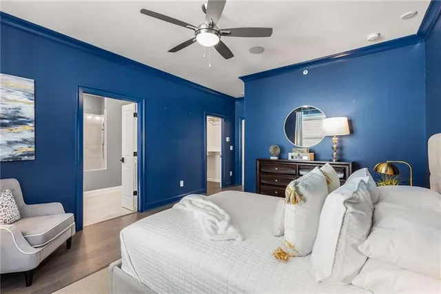 a bedroom with a bed a couch and a chandelier