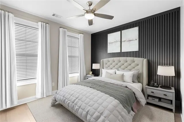 a bedroom with a bed and a large window with the outer view