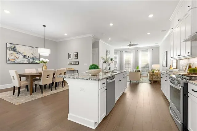 a large kitchen with kitchen island a sink a stove a dining table and chairs