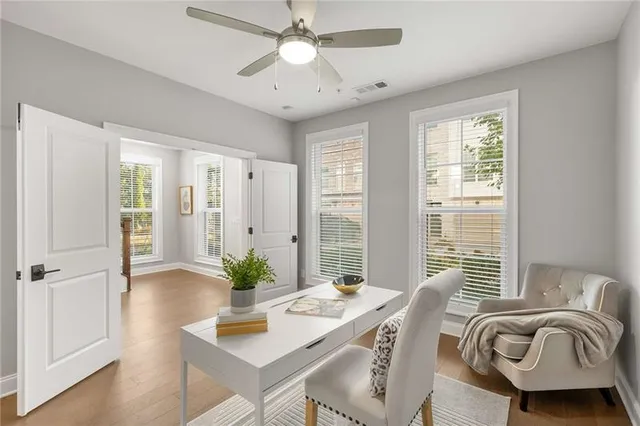 a view of a workspace with furniture and a window