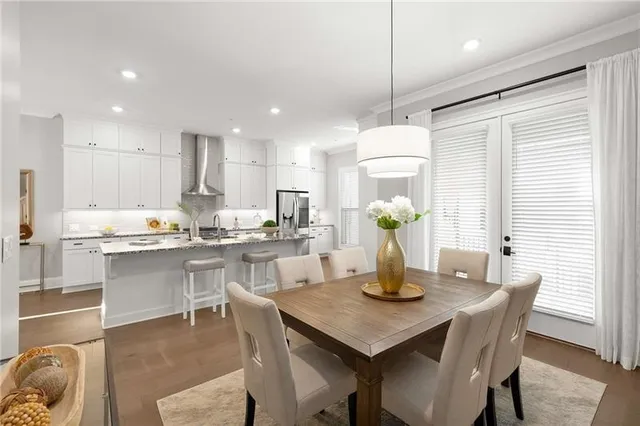 a kitchen with a dining table chairs and wooden floor