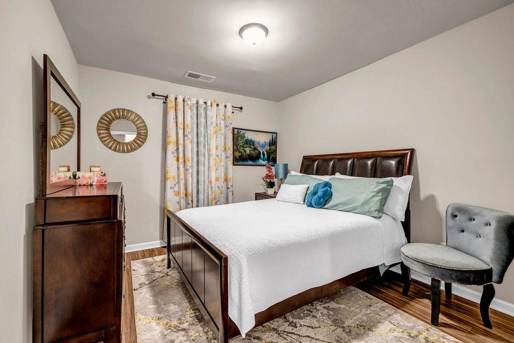 255 Skipjack Court Covington, GA 30016 - Photo 19 of 24 a bedroom with a bed and a lamp on dresser