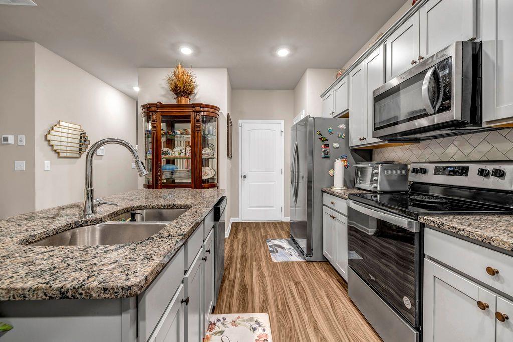 255 Skipjack Court Covington, GA 30016 - Photo 8 of 24 a kitchen with stainless steel appliances granite countertop a sink stove and refrigerator