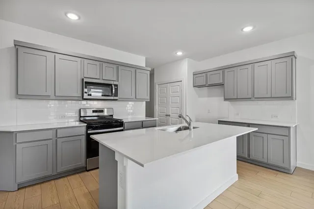 a kitchen with stainless steel appliances a sink stove and microwave