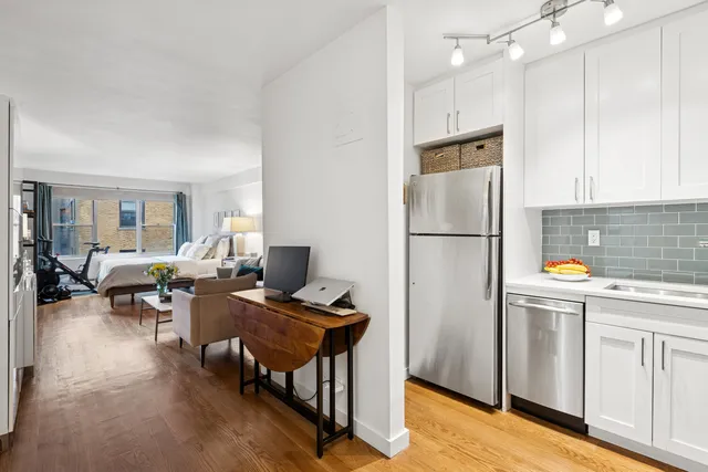 a kitchen with stainless steel appliances granite countertop a refrigerator sink and white cabinets