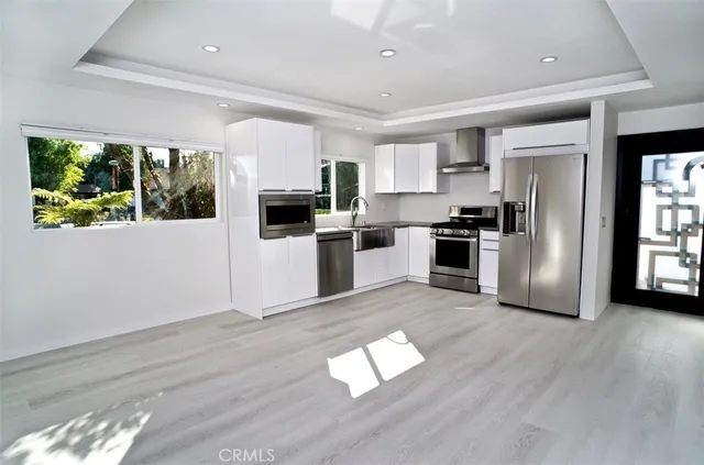 a kitchen with wooden floors and stainless steel appliances