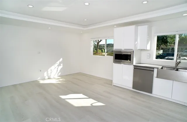 a view of a kitchen with wooden floor and a sink