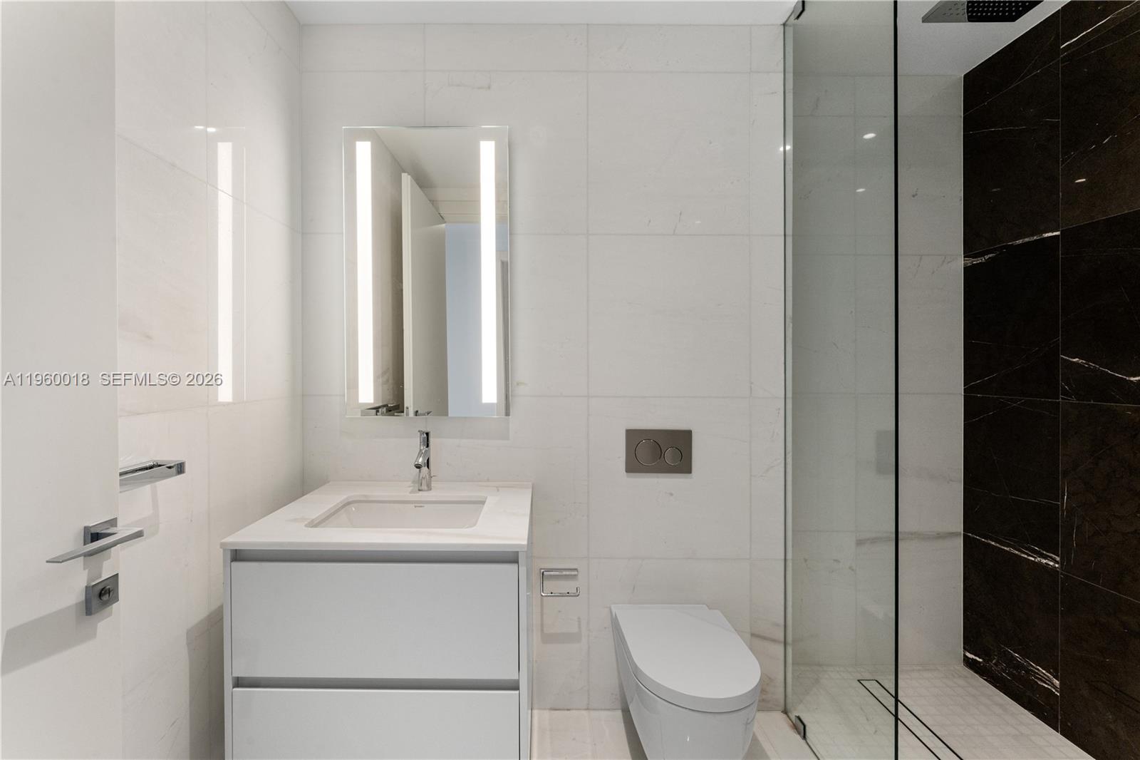 300 Biscayne Blvd Way, Unit 2009 Miami, FL 33131 - Photo 18 of 58 a bathroom with a toilet sink and mirror