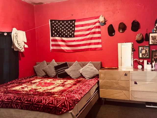 a bedroom with a bed and a lamp with the dresser