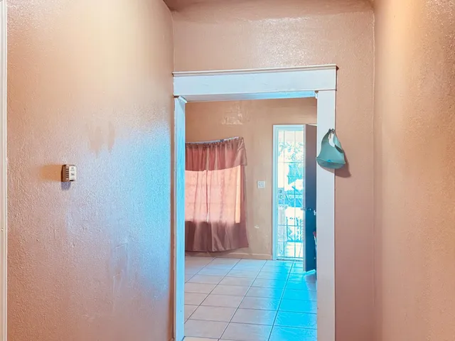 a view of a hallway with wooden floor and a living room