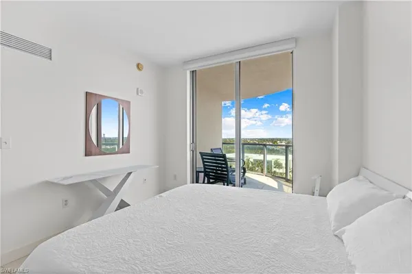a bedroom with a bed and large flat tv screen on the dresser