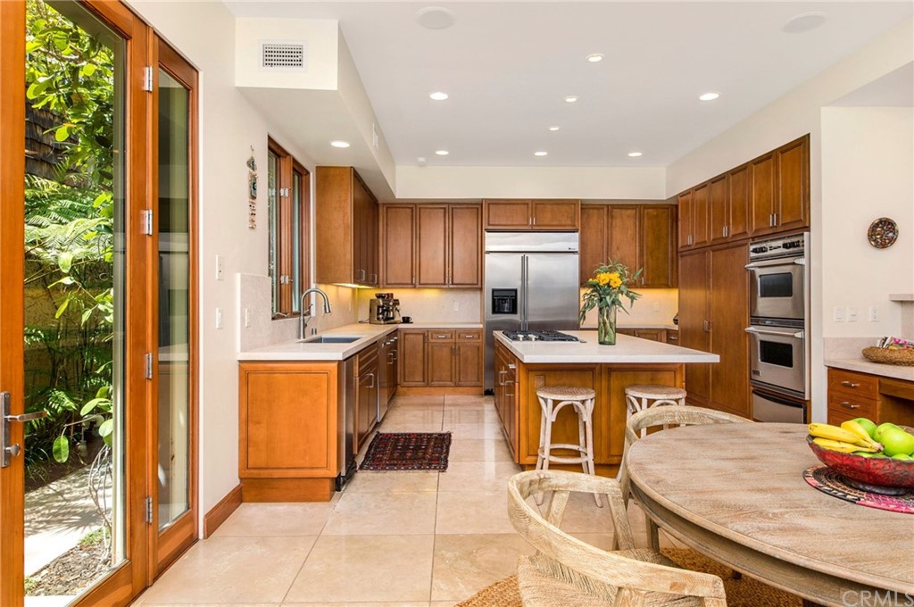 10 Smithcliffs Road Laguna Beach, CA 92651 - Photo 17 of 38 a kitchen with stainless steel appliances granite countertop a sink a stove a refrigerator and a dining table with wooden floor